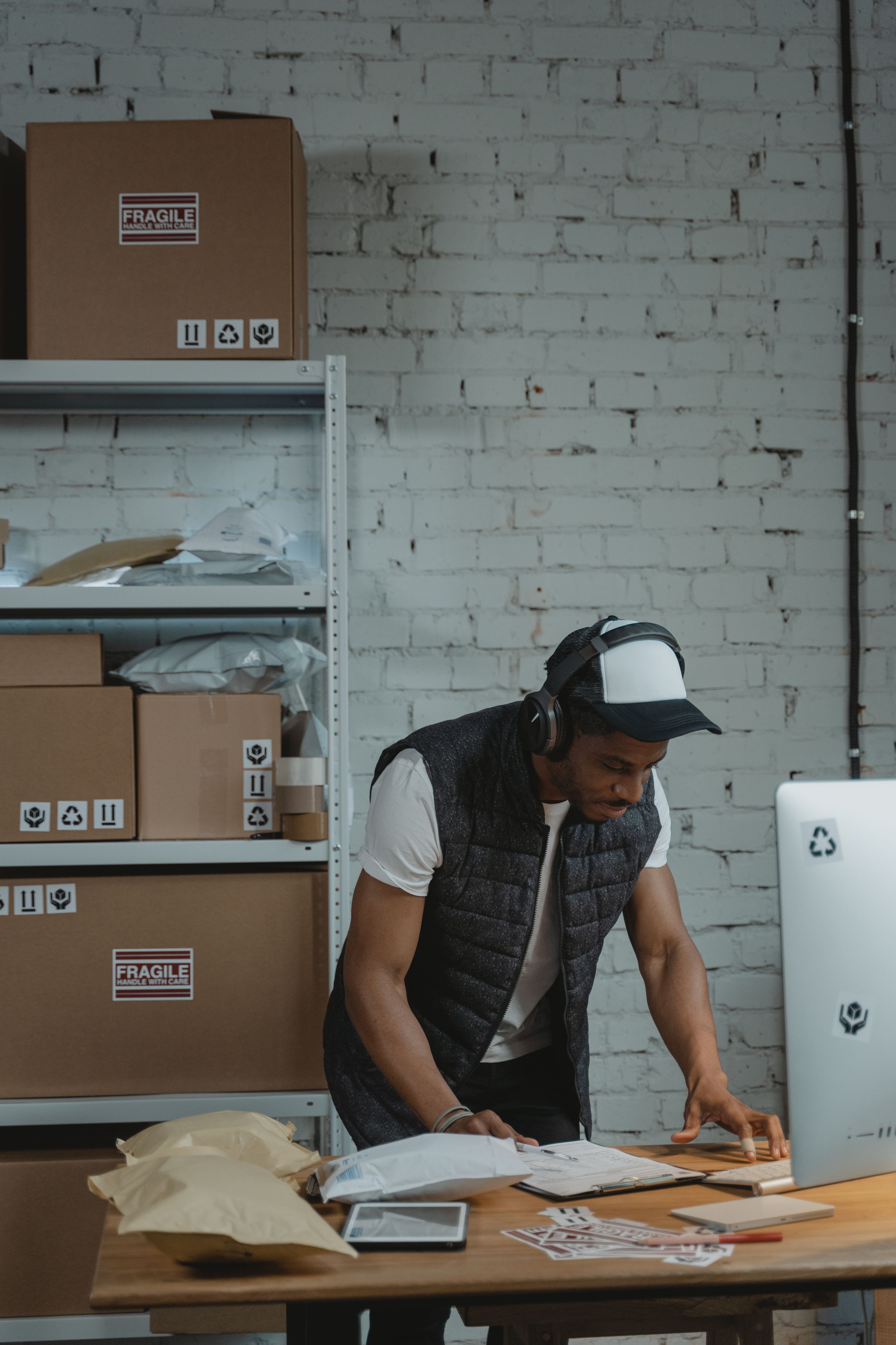 Receiving desk with a tablet, paperwork, and shipping supplies in a warehouse office.